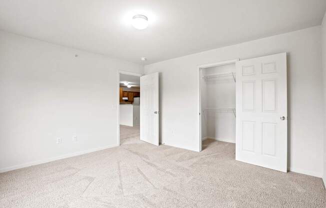 A white room with carpet and two doors.