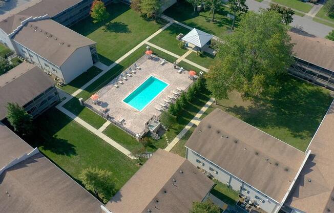 An aerial view of a neighborhood with a swimming pool in the center.