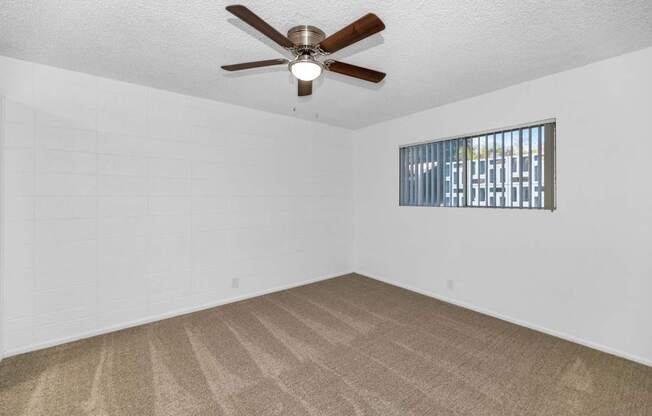 A room with a ceiling fan and carpeted floor at The Phoenix Apartments on 6th Avenue, Phoenix, AZ