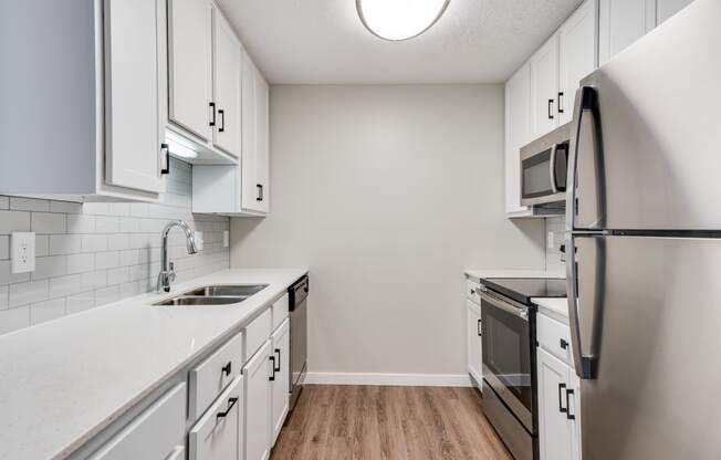 Upgraded Kitchen with White Cabinetry and Stainless Steel Appliances