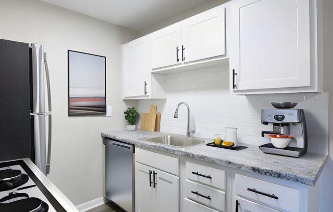 a kitchen with white cabinets and a stainless steel refrigerator