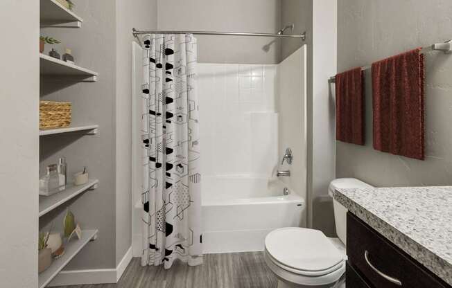 A white bathroom with a toilet, sink, and shower.
