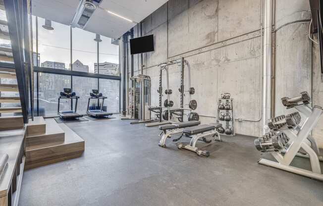 a gym with weights machines and a large window