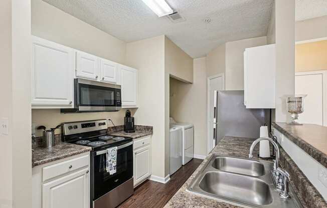 A kitchen with a black oven and white cabinets.