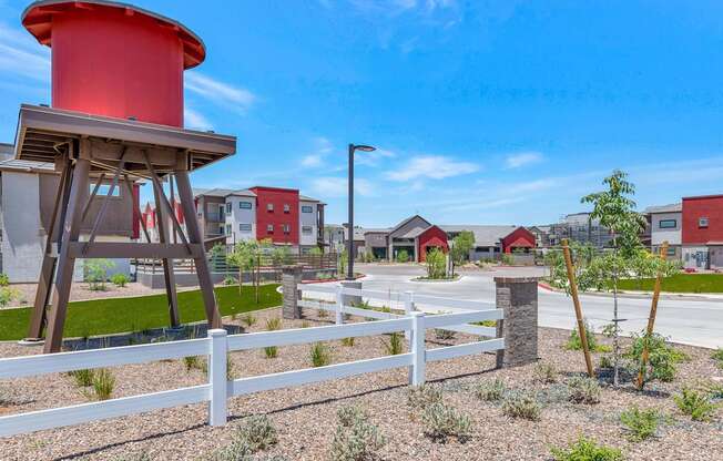 a red water tower sits in the middle of a parking lot at Weylyn Luxury Apartments, Arizona