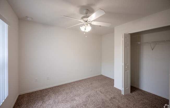 large bedroom with a ceiling fan and walk-in closet