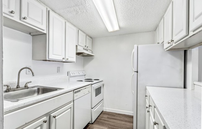 a kitchen with white cabinets and a sink and a refrigerator