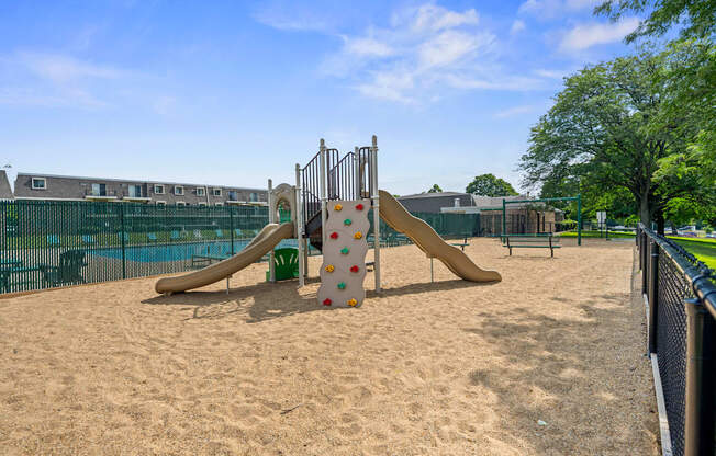 A playground with a slide and sand.