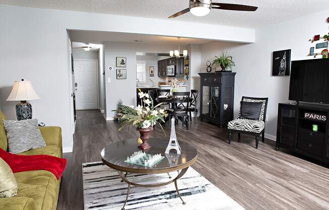 A living room with a glass table and a yellow couch.