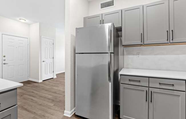 a renovated kitchen with stainless steel refrigerator and white cabinets at Switchback on Platte Apartments, Littleton, Colorado