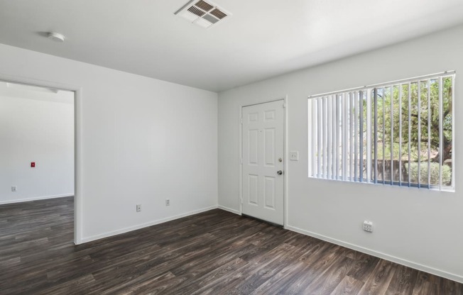 the living room of an empty house with a window and a door