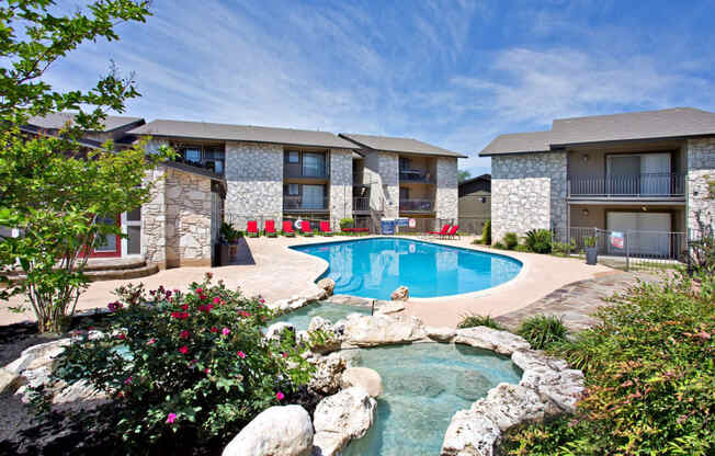 a swimming pool with a pool house and a resort style pool