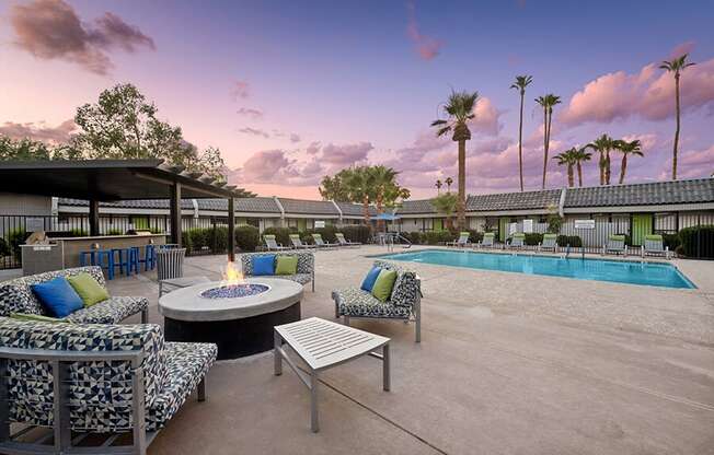 Outdoor Fire Pit Area and Swimming Pool with Lounge Furniture at Arcadia on 49th Apartments located in Phoenix, AZ.