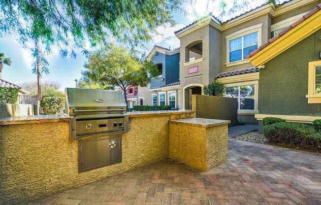 A backyard with a grill and a wall.