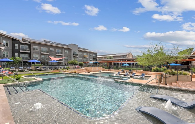 A large swimming pool with a slide in the middle of a residential area.