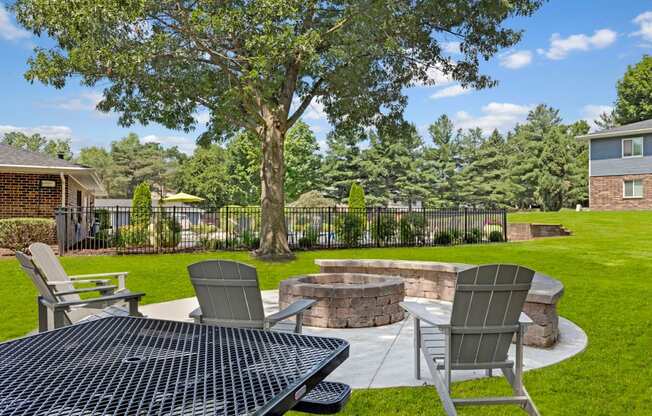 the backyard has a fire pit and patio with two chairs and a table