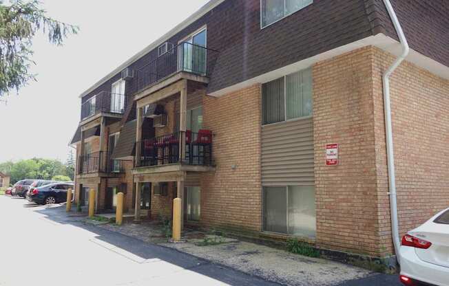 A red and white sign is on the side of a brick building.