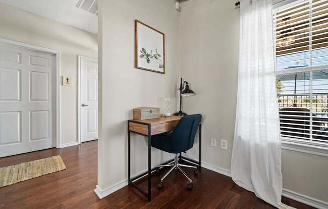A room with a desk and chair in it.