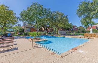 Palisades at Bear Creek community pool with green trees and water feature