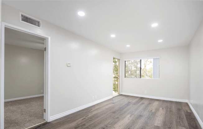 an empty living room with white walls and wood flooring at Huntington Terrace North Senior, Huntington Beach, CA
