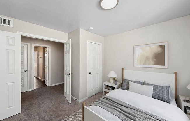 Model Bedroom with Carpet and Hallway View at Hidden Creek Apartments in Lewisville, TX.
