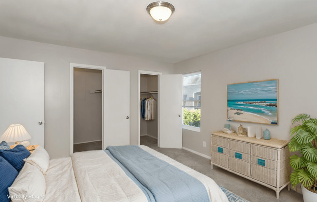 A bedroom with a bed, nightstand, and a painting on the wall.