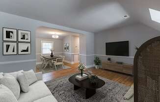 Virtually staged living room with a couch and a table and a tv