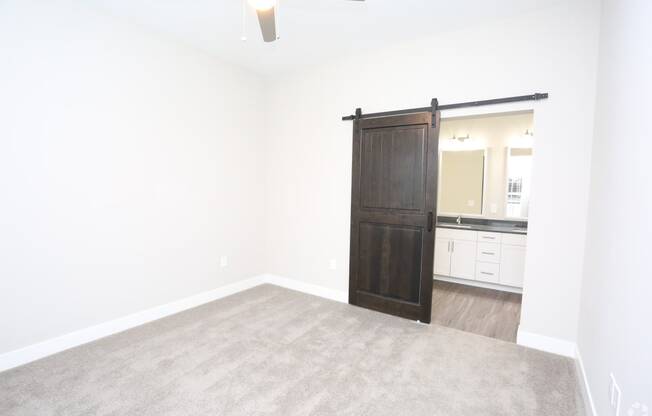 an empty living room with a wooden sliding door to a bathroom at Century Baxter Avenue, Kentucky, 40204