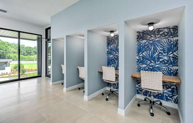 an office with blue and white wallpaper and white chairs