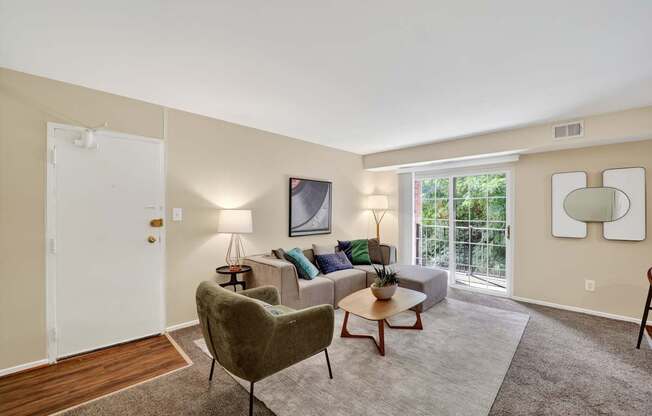 A living room with a green chair and a white couch.