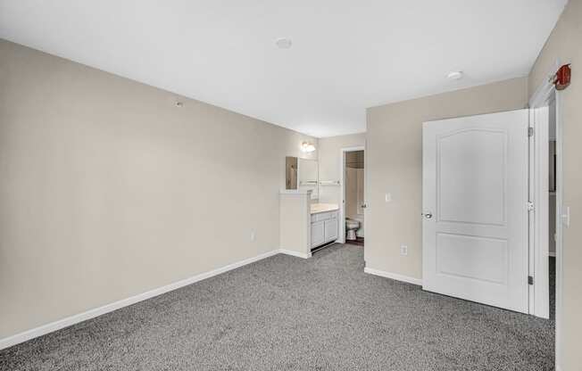 a renovated living room with a white door and a kitchen