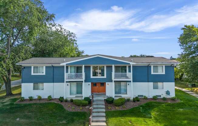 the view of a blue and white house with a orange door at Town & Country Apartments - Wixom, MI, Wixom