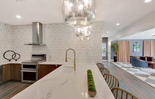 A modern kitchen with a long white island in the middle.