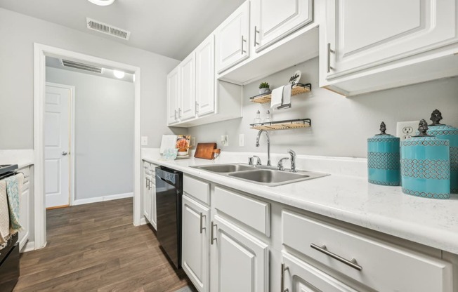 a kitchen with white cabinets and a sink    and a door to a