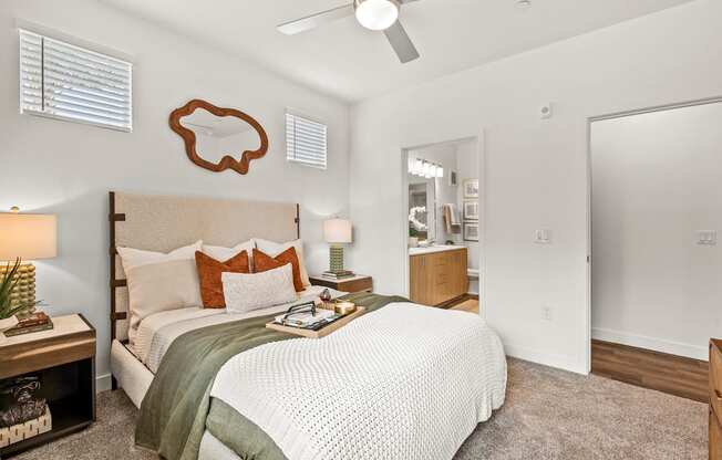A bedroom with a bed, nightstand, and a ceiling fan.