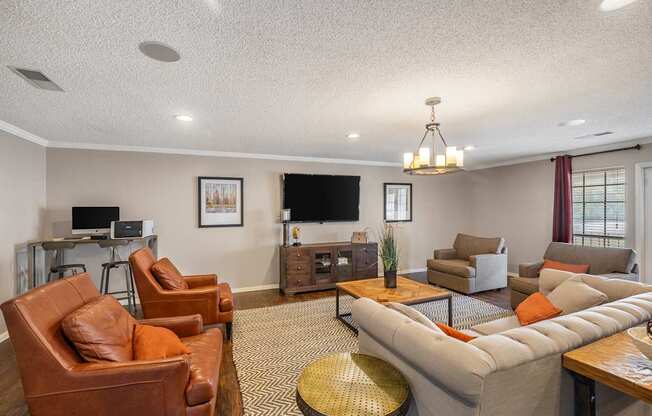 A living room with a brown leather chair and a grey sofa.