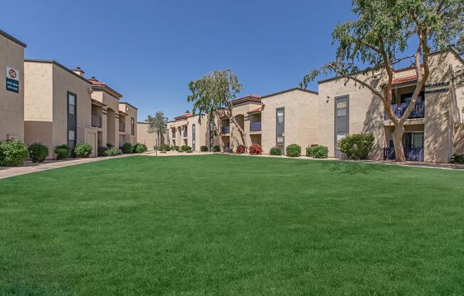 a large brick building with green grass in front of a house