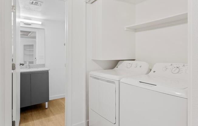 A white washing machine and dryer in a laundry room.