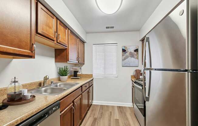 A kitchen with wooden cabinets and a stainless steel refrigerator.