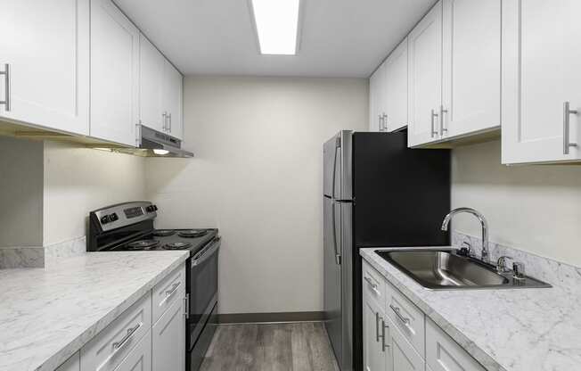 Spacious kitchen with Plank Flooring, Overhead Lighting, and White Cabinetry at Casa Blanca Apartment Homes, Everett