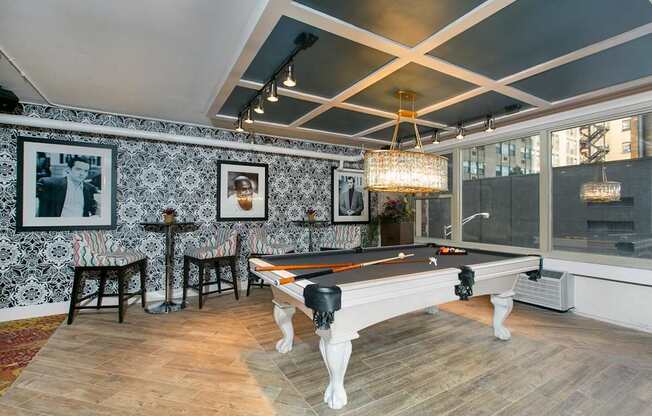 the pool room has a chandelier and a view of the city