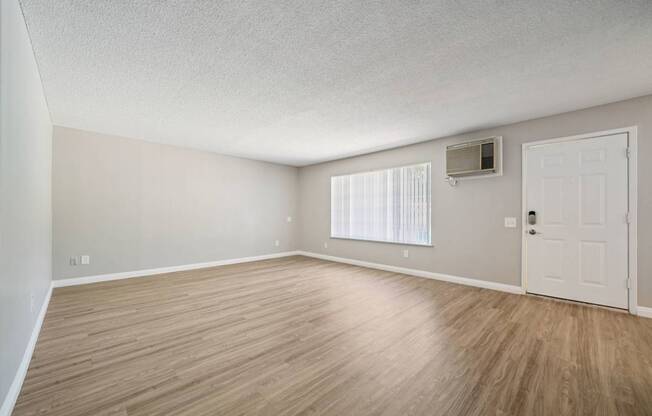 A room with wooden flooring and a white door.