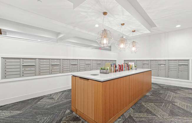 A reception desk with a white counter and a brown wooden frame is in the middle of a room with grey carpeting and white walls.