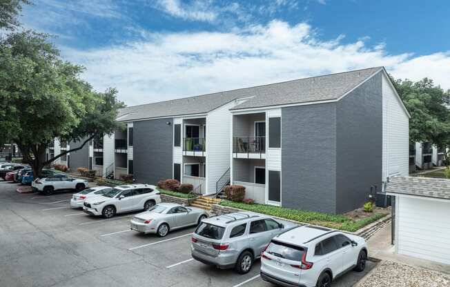 a gray building with cars parked in front of it