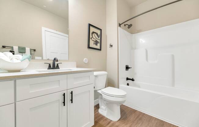 a bathroom with white cabinets and a sink and a toiletat Solace at Ballpark Village, Goodyear, AZ