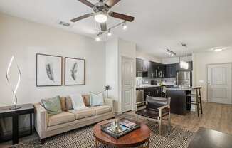 A living room with a couch, coffee table, and a ceiling fan.