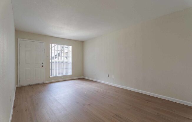 A room with a white door and a window with blinds.