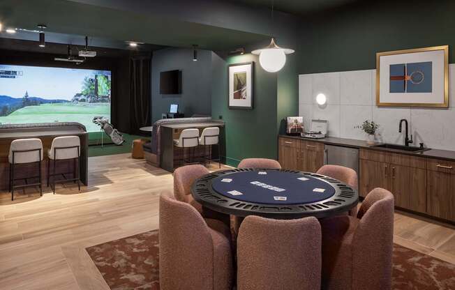 A room with a table and chairs and a screen in the background.