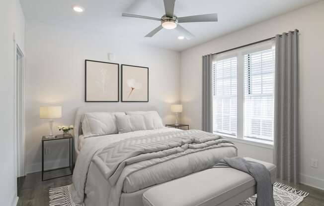 a white bedroom with a large bed and a ceiling fan