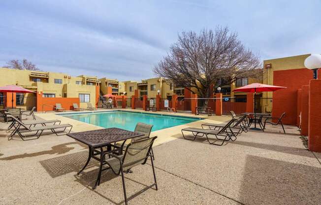 A pool area with a table and chairs.